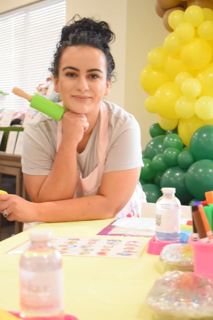 Nilani with a rolling pin at a kids cookie class table